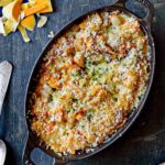 An oval gratin dish filled with butternut squash gratin