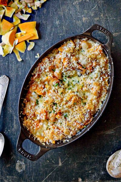An oval gratin dish filled with butternut squash gratin