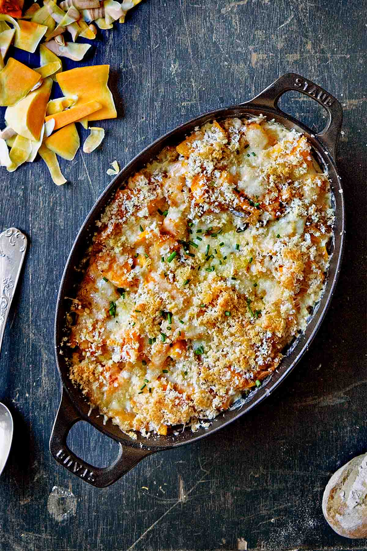 An oval gratin dish filled with butternut squash gratin