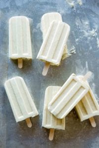 Three eggnog ice pops with wooden popsicle sticks.