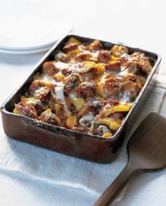 A rectangular casserole dish filled with baked polenta with sausage and cheese.