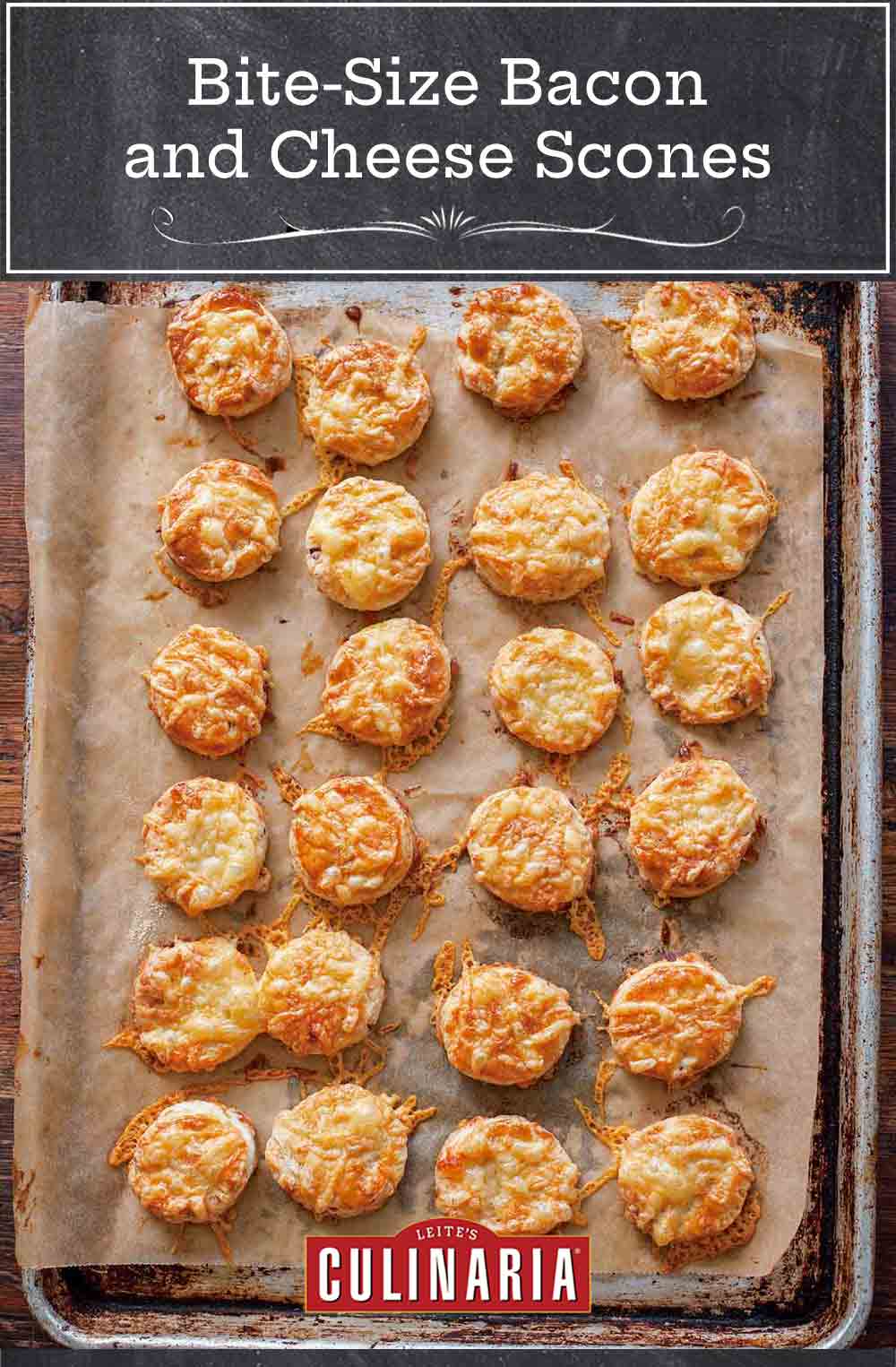 Bite-size bacon and cheese scones with smoked bacon and melted Asiago on top on a parchment-lined baking sheet