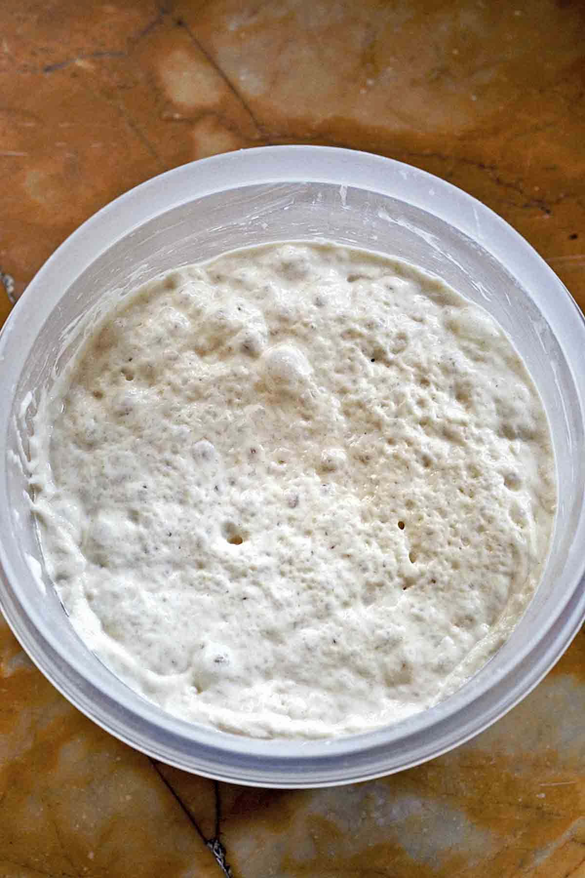 Baker using a wooden spoon to stir dough in mixing bowl stock