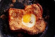 A slice of toast in a skillet with an egg in the hole of the toast.
