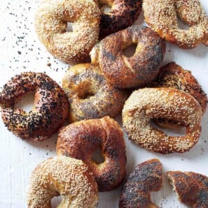 A variety of homemade bagels on a white surface.