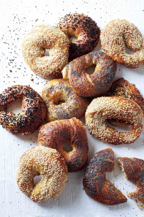 A variety of homemade bagels on a white surface.