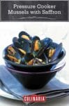 A bowl of pressure cooker mussels with saffron sprinkled with chopped parsley and in a yellow broth set in another bowl on top of a napkin