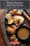 Pieces of roast chicken wth a small dish of pan gravy and a halved lemon and bulb of garlic on an oval metal tray.