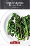 A white plate of skillet-charred broccolini.