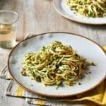 A gold-rimmed white plate topped with a serving of walnut parsley pesto pasta.