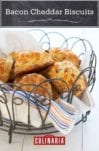 A wire basket lined with a napkin and filled with bacon Cheddar biscuits.
