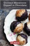 Five coconut macaroons dipped in chocolate arranged on a floral-patterned china plate.