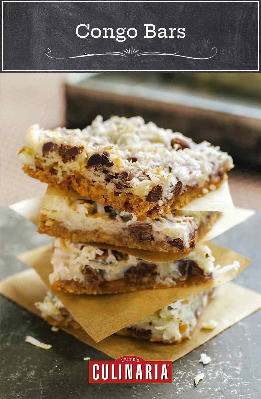 Stack of four Congo bars made of coconut, chocolate, graham crackers, each on a square of paper