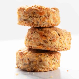 Three ham and Cheddar biscuits stacked on top of each other.