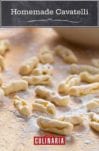 Pieces of uncooked homemade cavatelli on a floured surface.