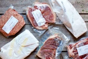 Several packages of frozen meat that need instruction on how to defrost meat safely.