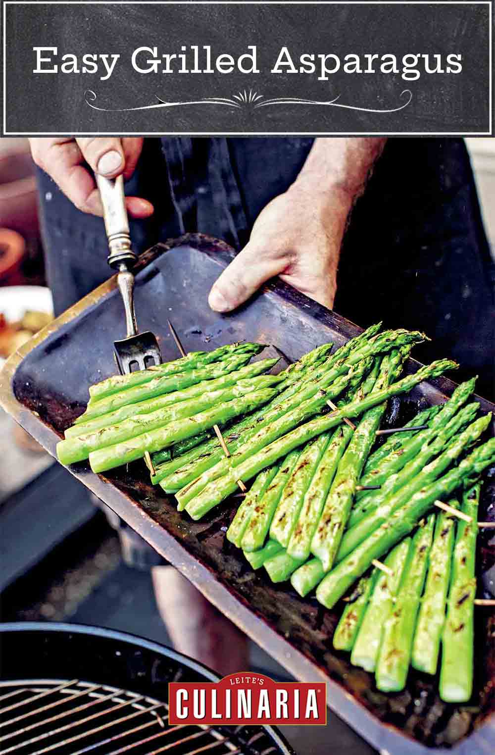 A cook demonstrating how to grill asparagus with several rafts of asparagus spears connected with wooden skewers.