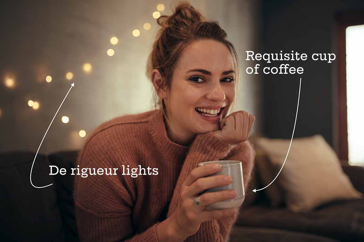 A model with a cup of coffee demonstrating hygge.