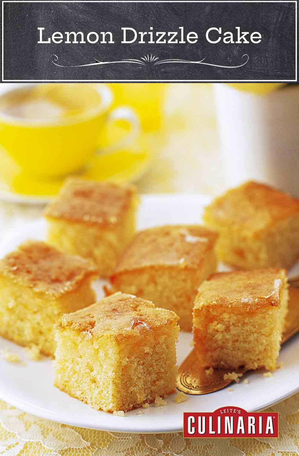 Squares of lemon drizzle cake on a white plate with a cake server resting underneath and a cup of tea and vase of flowers in the background.