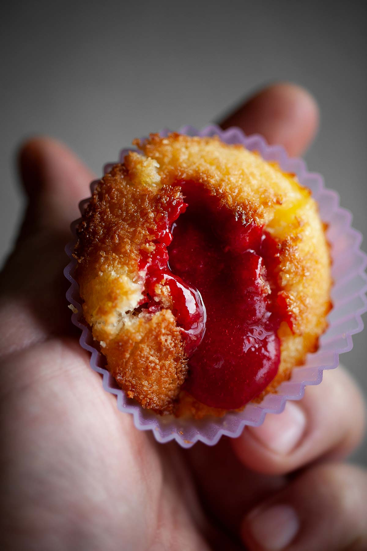 A person holding a Portuguese coconut custard tart.