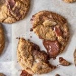 Several ginger chocolate chunk cookies on a piece of parchment paper.