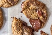 Several ginger chocolate chunk cookies on a piece of parchment paper.