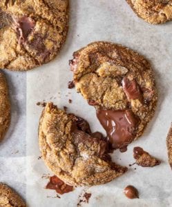 Several ginger chocolate chunk cookies on a piece of parchment paper.