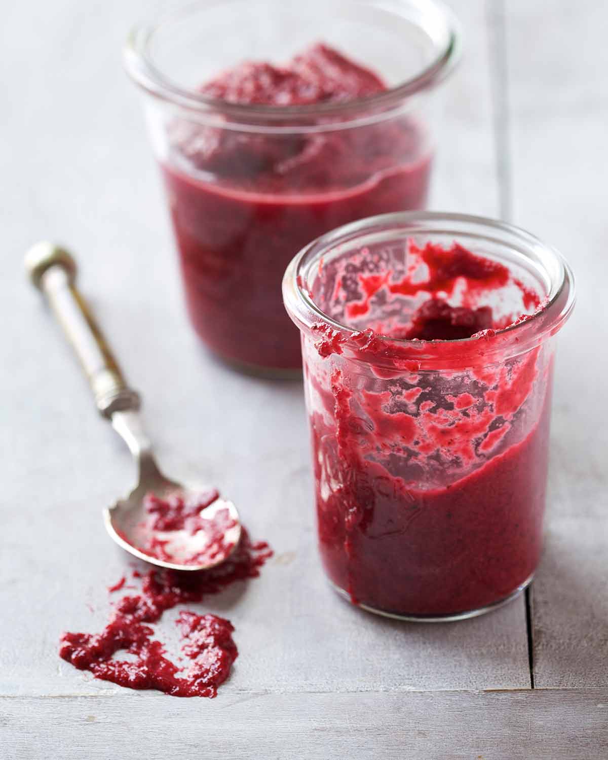 Two glass jars of homemade chrain with a silver spoon lying beside them.