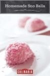 A pink homemade sno ball--coconut-covered dome--on a white plate with two more sno balls in the back.