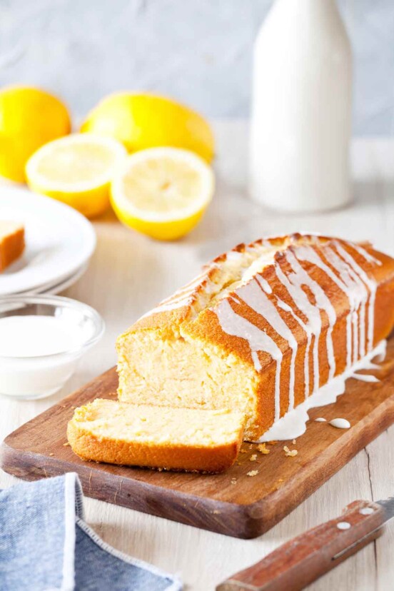 Ina Garten's lemon cake, a pound cake, on a cutting board, drizzled with a lemon glaze