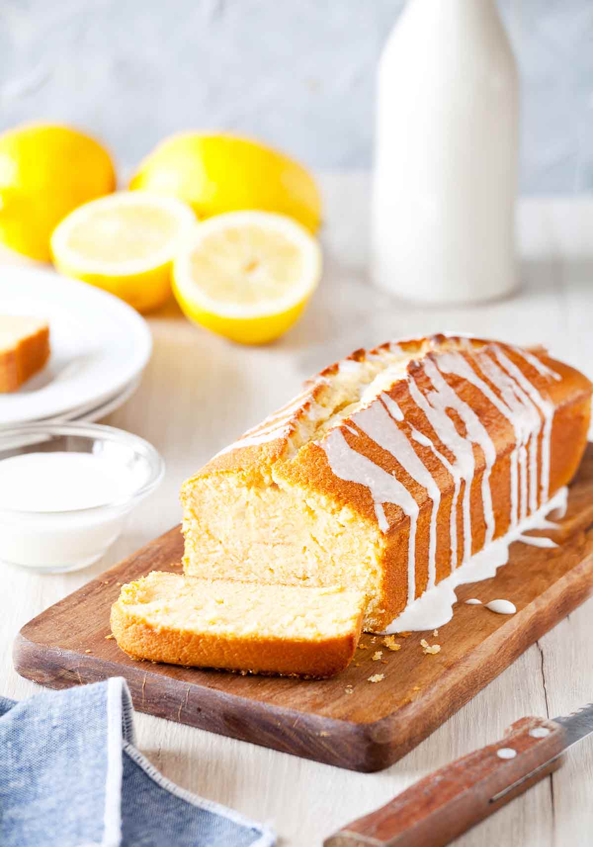 Ina Garten's lemon cake, a pound cake, on a cutting board, drizzled with a lemon glaze