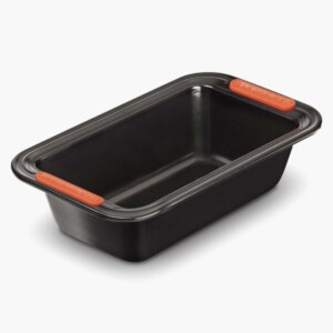 A black Le Creuset loaf pan with white background.