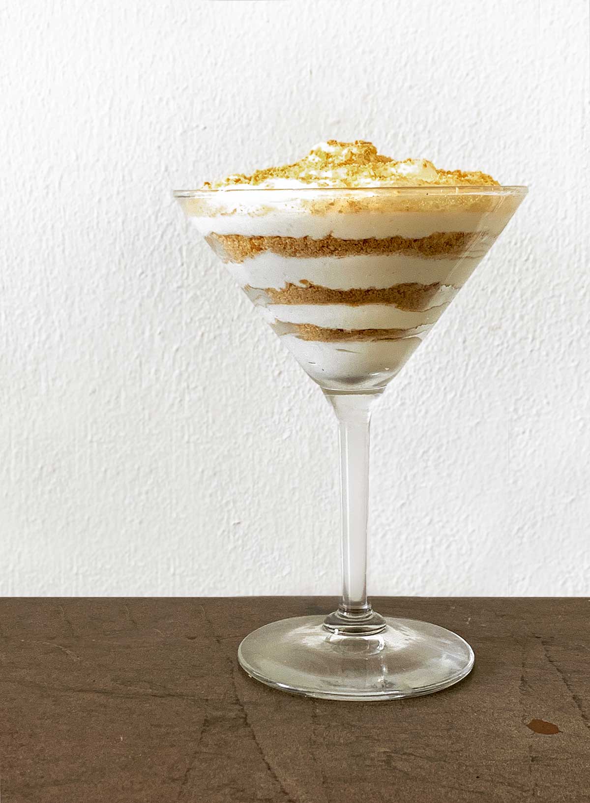 A serving of Portuguese sawdust pudding layered in a martini glass.