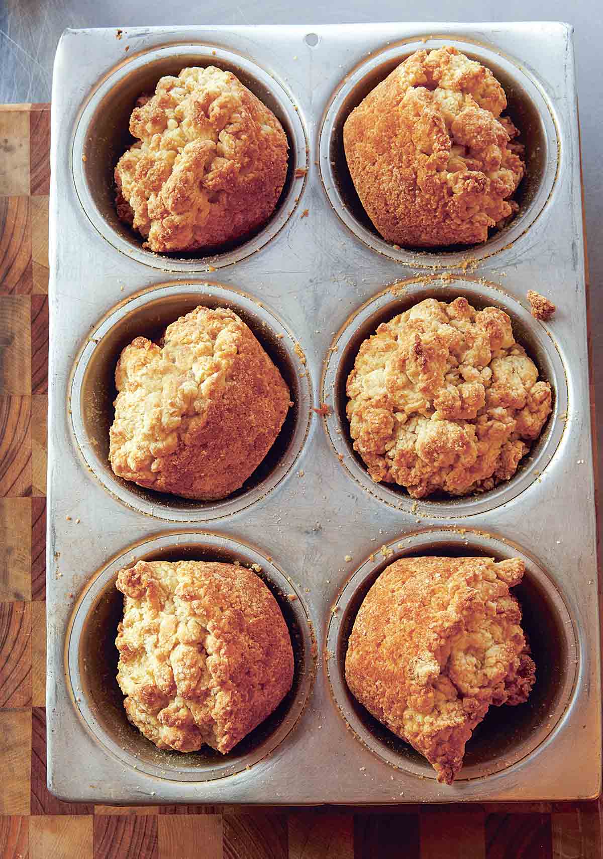 Six Alabama muffin biscuits in a muffin tin.