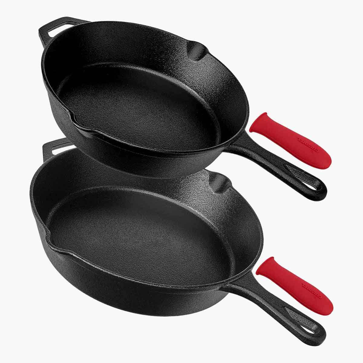 Two cast iron skillets with red silicone protective sleeves.
