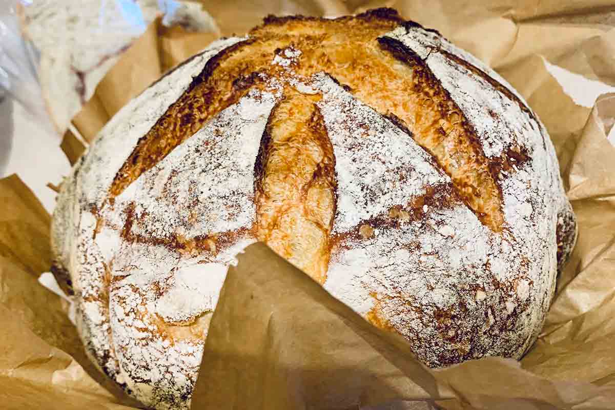 Halved slices of sourdough stacked on top of each other on a white and grey marble surface.