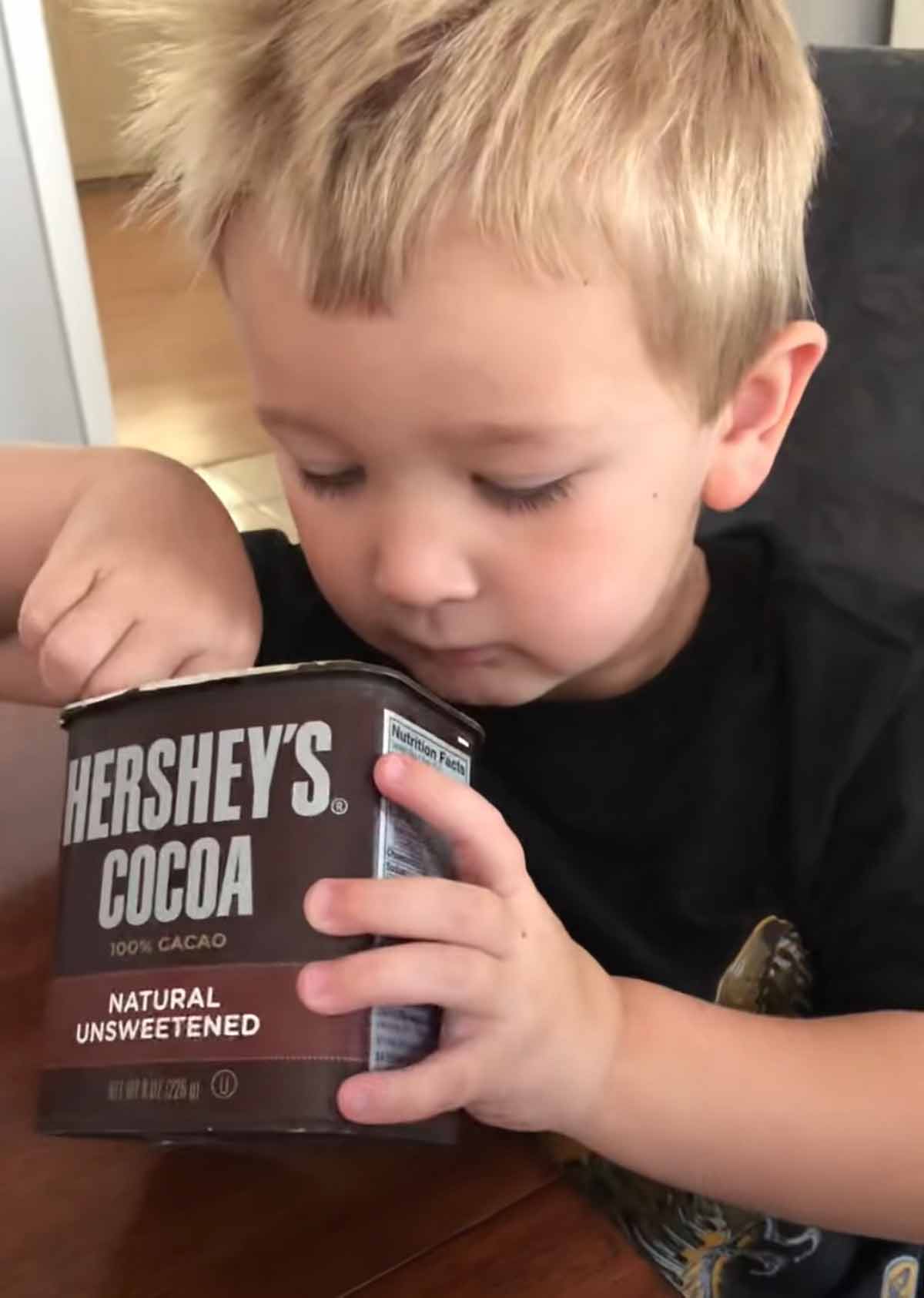 A little boy eating cocoa powder as part of the article on the difference between natural and Dutch-process cocoa powders.