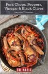 Brined pork chops cooked with red peppers, onions, black olives, and garlic in a skillet on stone