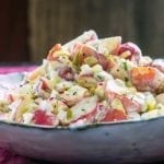 A bowl mounded with potato salad with sweet pickle relish.