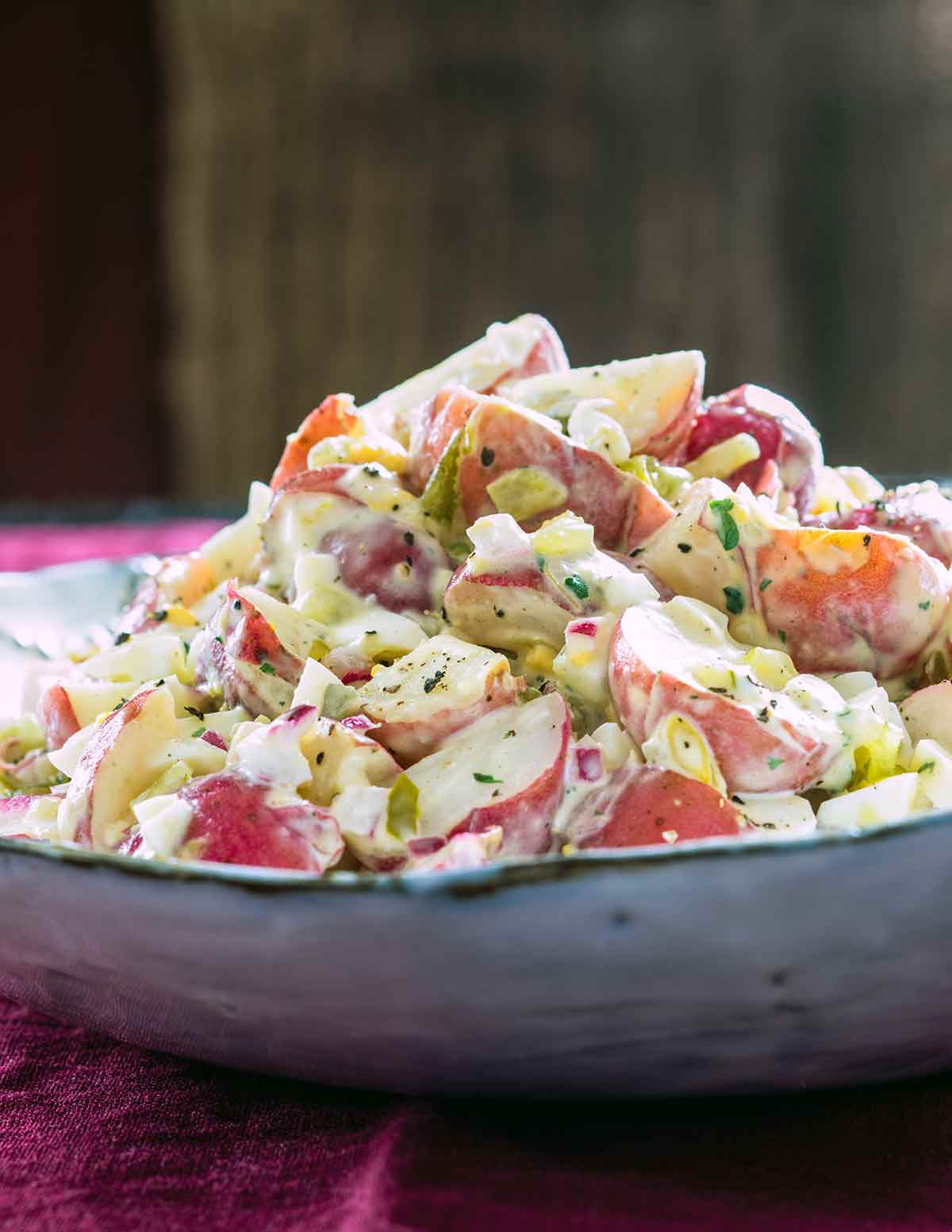 A bowl mounded with potato salad with sweet pickle relish.