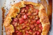 A whole baked rhubarb-ginger crostata on a piece of parchment paper.