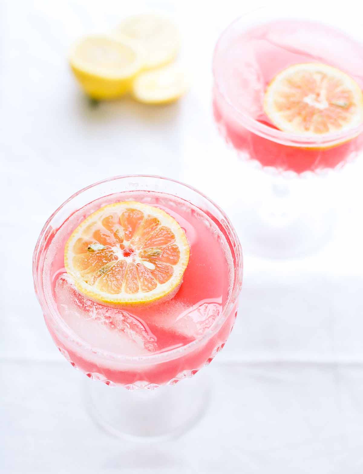 Two glasses of rhubarb sour with lemon slices floating in them