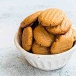 A white bowl filled with soft peanut butter cookies.