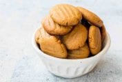 A white bowl filled with soft peanut butter cookies.