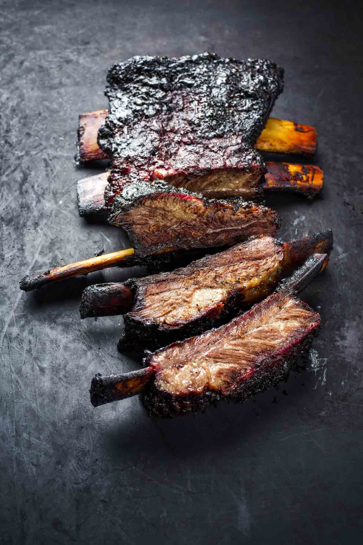 A slab of barbecued beef back ribs cut into individual ribs.