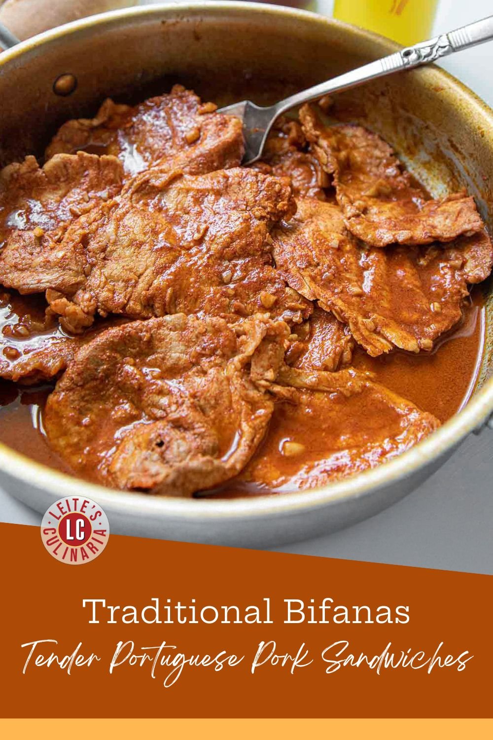 Thin slices of pork cooking in a golden-red paprika sauce inside a stainless steel skillet.