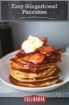 A stack of easy gingerbread pancakes topped with bacon, maple syrup, and creme fraiche in a white bowl.