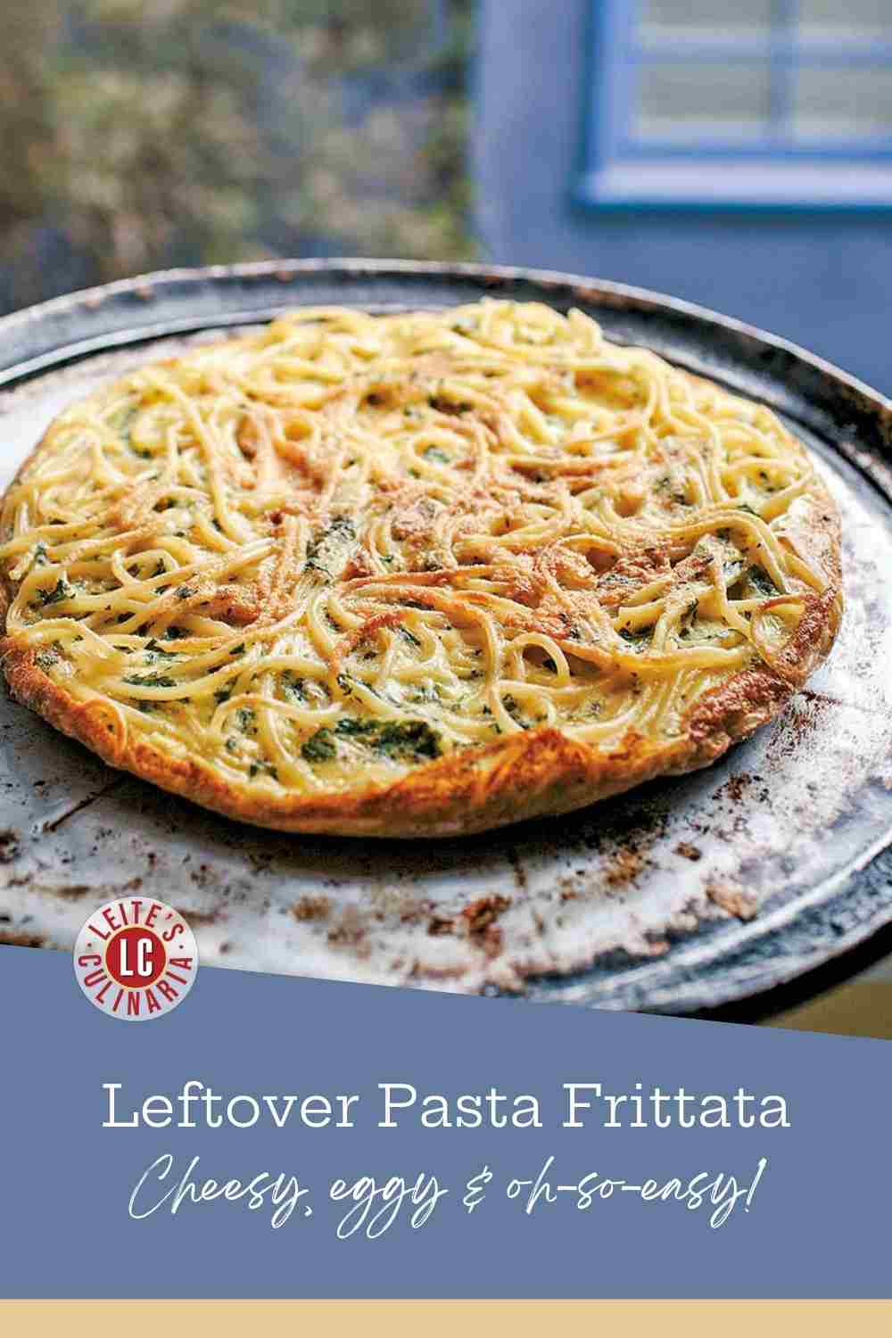 Crispy golden-brown pasta frittata with visible strands of spaghetti and fresh green herbs on a platter.