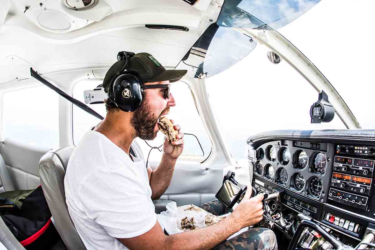 Matt Moore flying a plane taking a bit out of food.