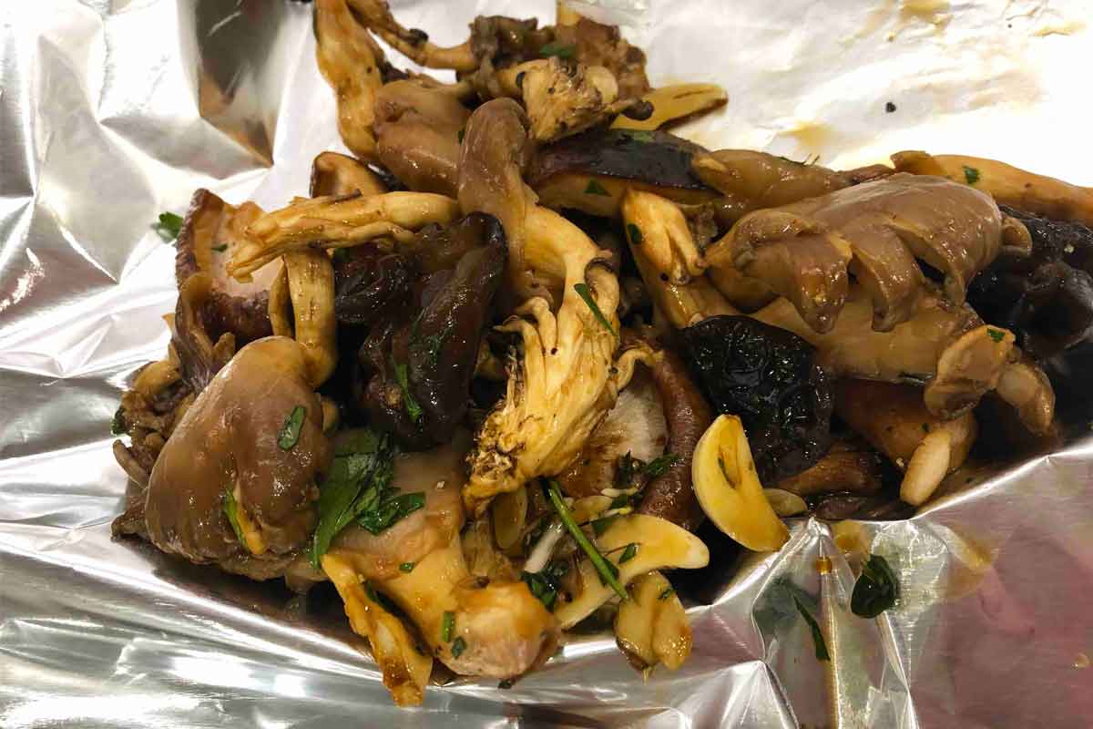 A close view of baked mushrooms in foil packets.